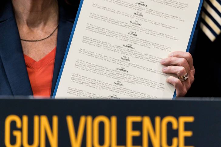 New York Governor Kathy Hochul holds up newly signed gun safety legislation during a bill signing ceremony at a community center in the Bronx on June 6, 2022.